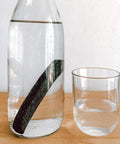 Bouteille contenant un charbon actif pour améliorer la qualité de l'eau naturellement - solution zero dechet